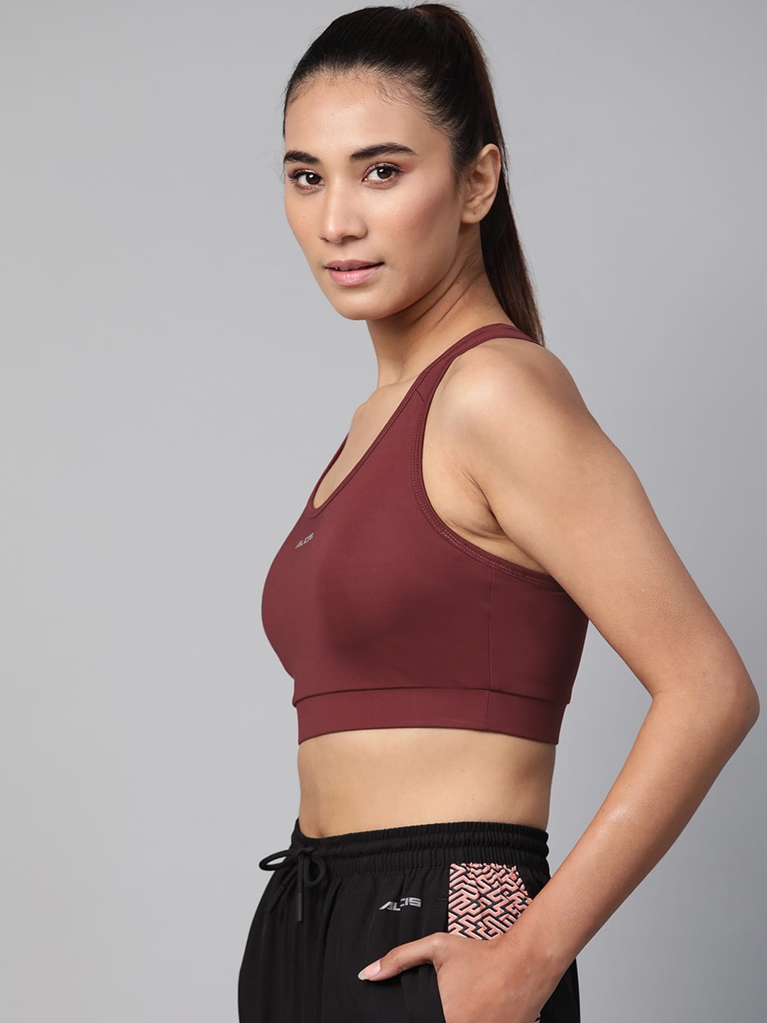Alcis maroon workout bra for women with non-wired support and breathable polyester lycra fabric.