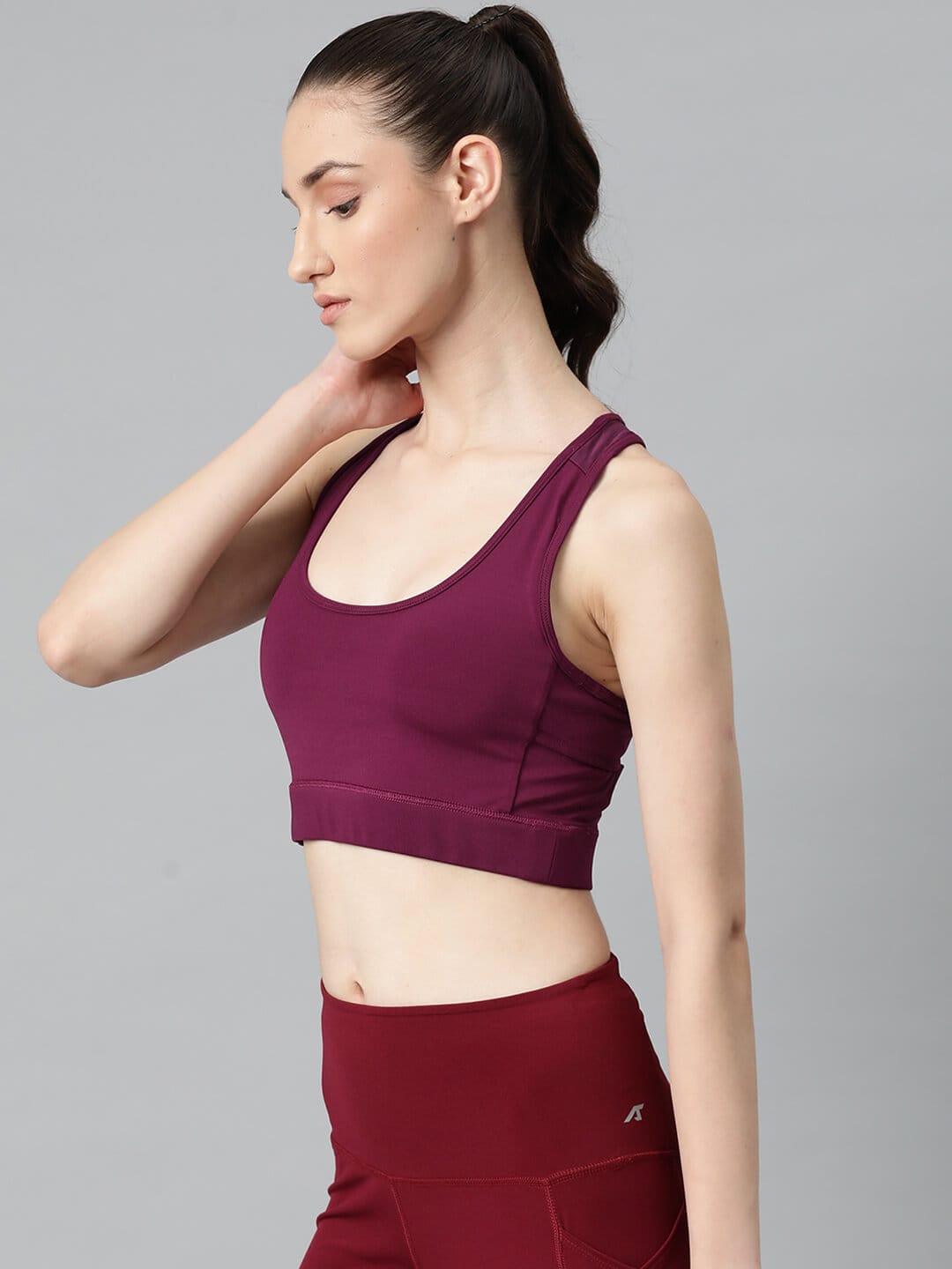 Women's sleeveless red sports bra with round neck, moisture-wicking technology and supportive fit by Alcis.